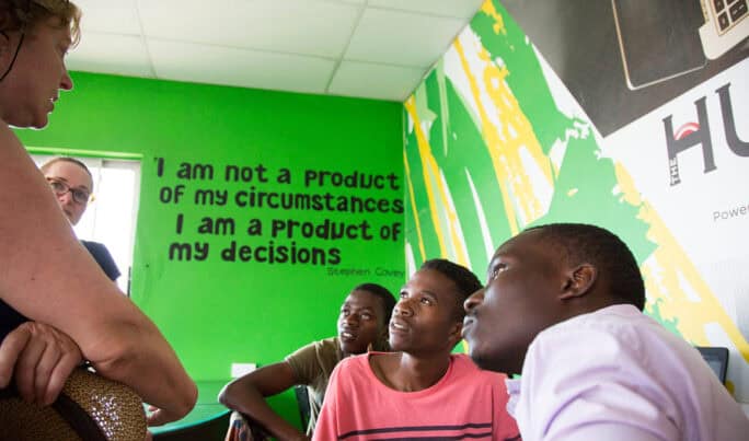 Responsible Tourism: "I am not a product of my circumstances, I am a product of my decisions" quote on school wall with Malawi boys & Orbis volunteer tourist