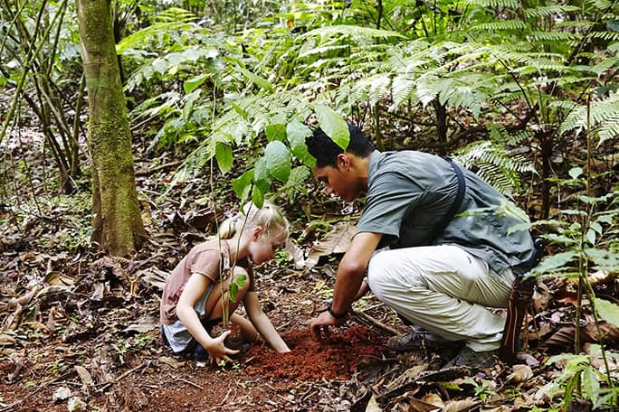Guide planting tree with child guest, Lapa Rios, Costa Rica