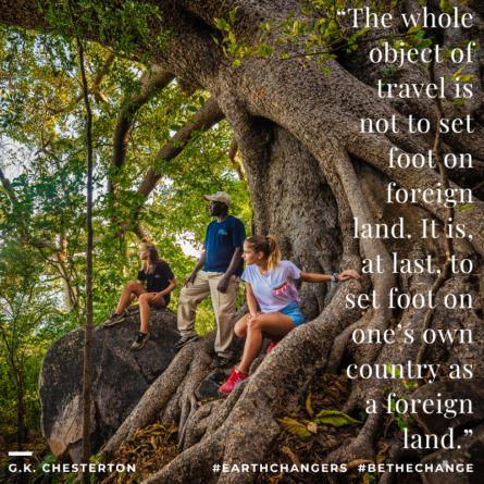 At Malawi's Blue Zebra Island Lodge on Nankoma Island, three hikers rest on massive tree roots and boulders in a forest, gazing outward, with an overlaid G.K. Chesterton quote: "The whole object of travel is not to set foot on foreign land. It is, at last, to set foot on one's own country as a foreign land." #EarthChangers #BeTheChange #MondayMotivation #MotivationMonday #MotivationalQuote #QuoteOfTheDay #GKChesterton